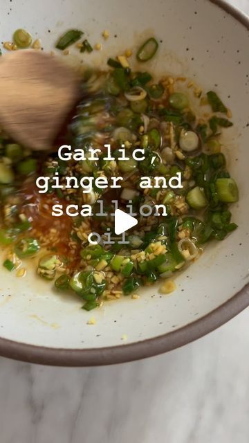 garlic, ginger and scallion oil in a white bowl with a wooden spoon