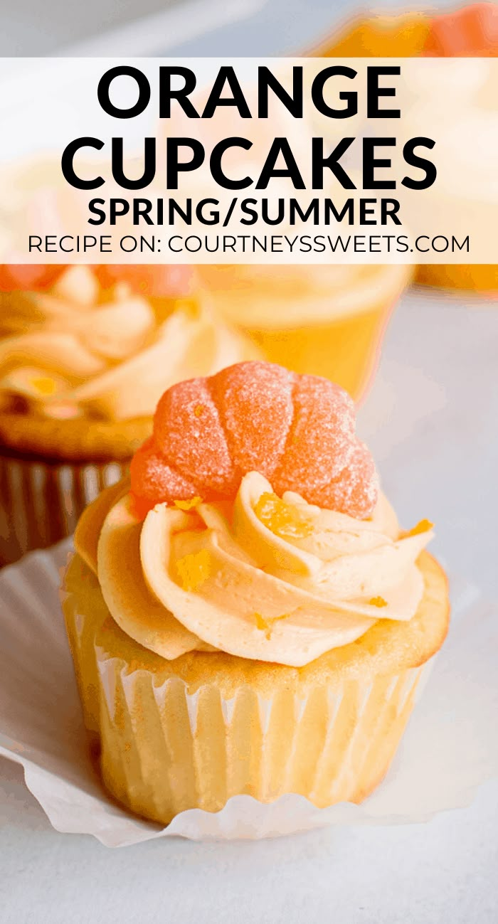 orange cupcakes with white frosting and fresh fruit on top, sitting on a paper plate