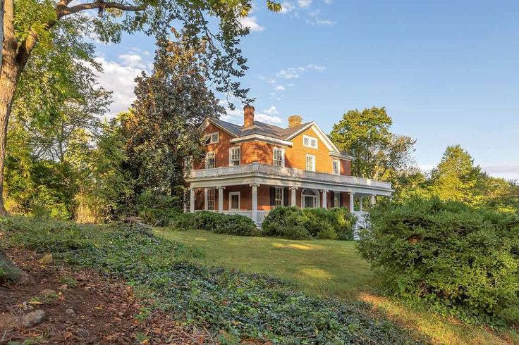 a large house sitting on top of a lush green field