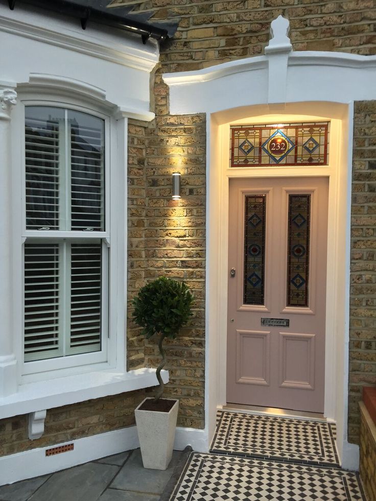 a white front door sitting next to a brick building