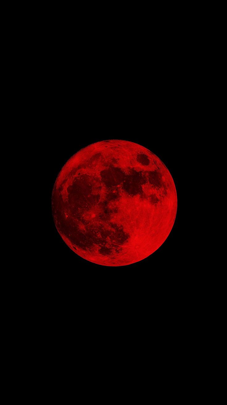 a red moon is seen in the dark sky