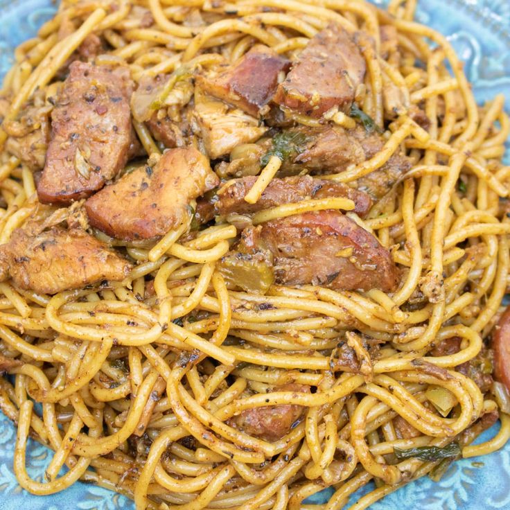 a blue plate topped with pasta and meat