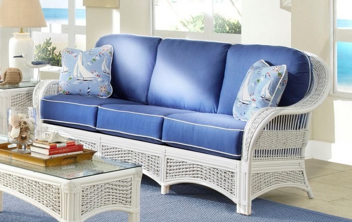 a living room with blue and white furniture in it's centerpiece, including a wicker coffee table