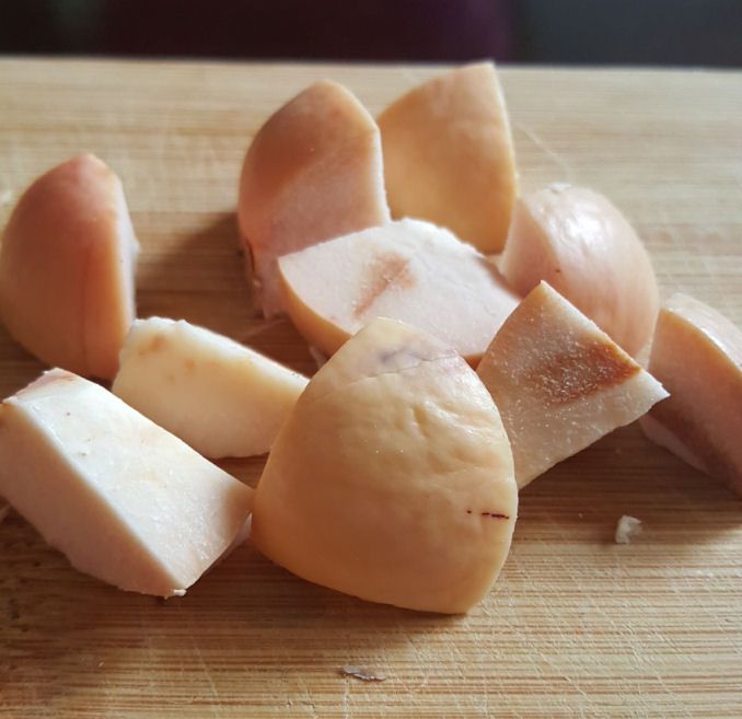 several pieces of cheese sitting on top of a wooden cutting board