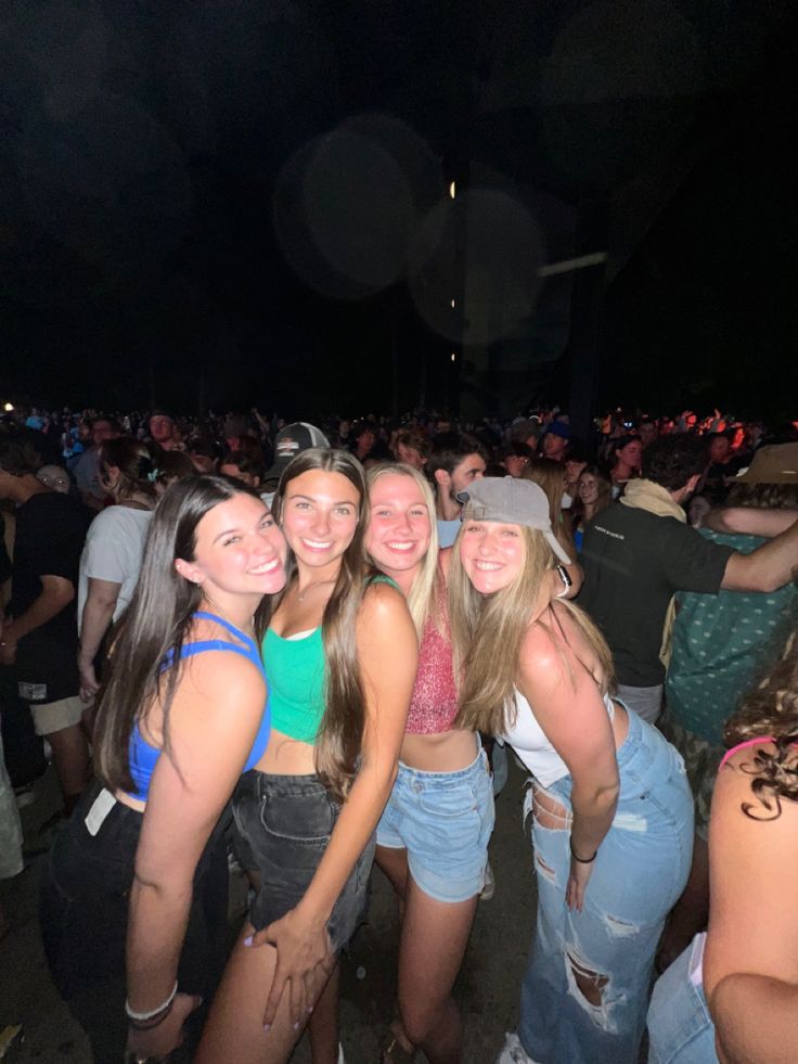 a group of young women standing next to each other in front of a large crowd