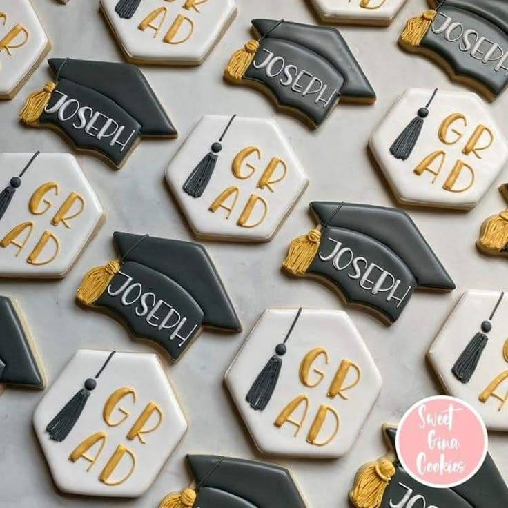 decorated cookies with graduation caps and tassels are displayed in front of a backdrop