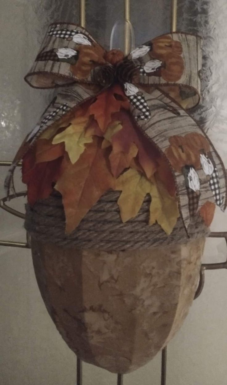 a basket with fall leaves on it hanging from a wire rack in front of a door