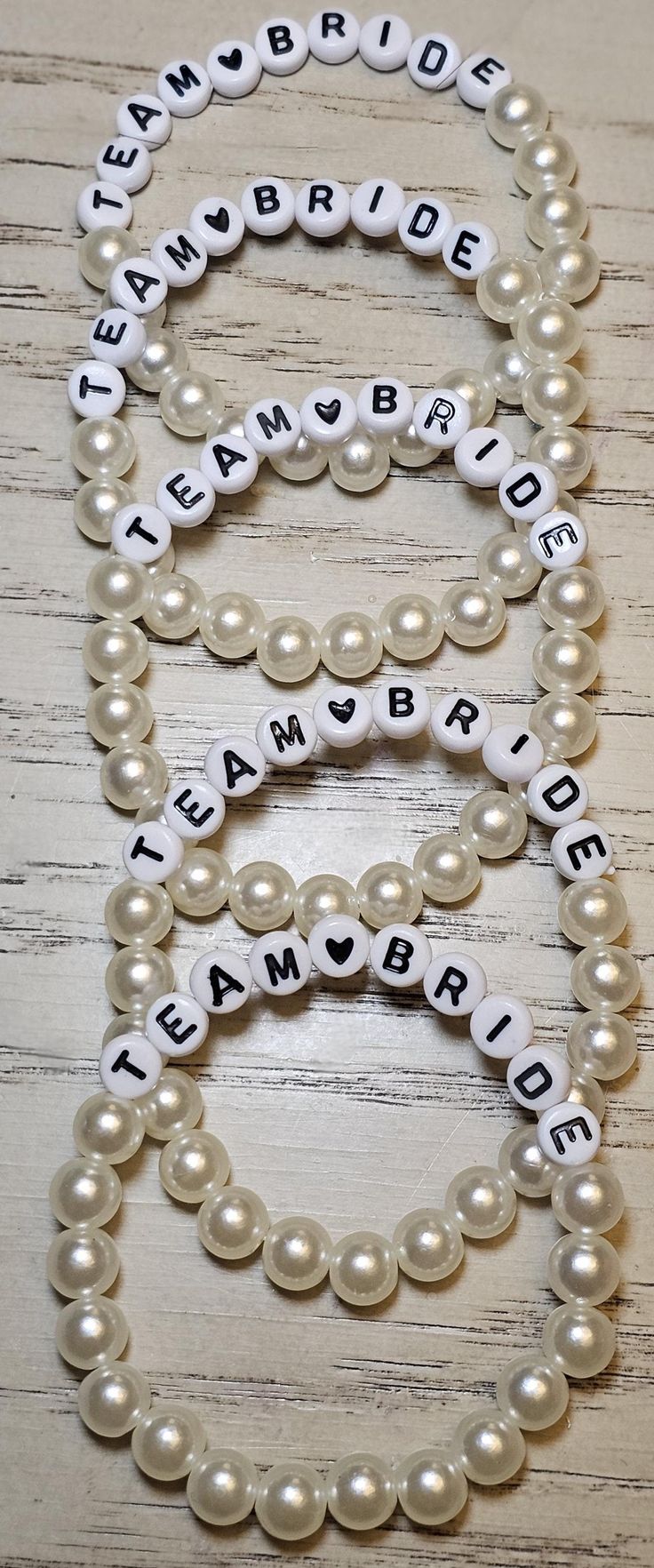 two bracelets that say team bride, team bride and team bride with pearls on them