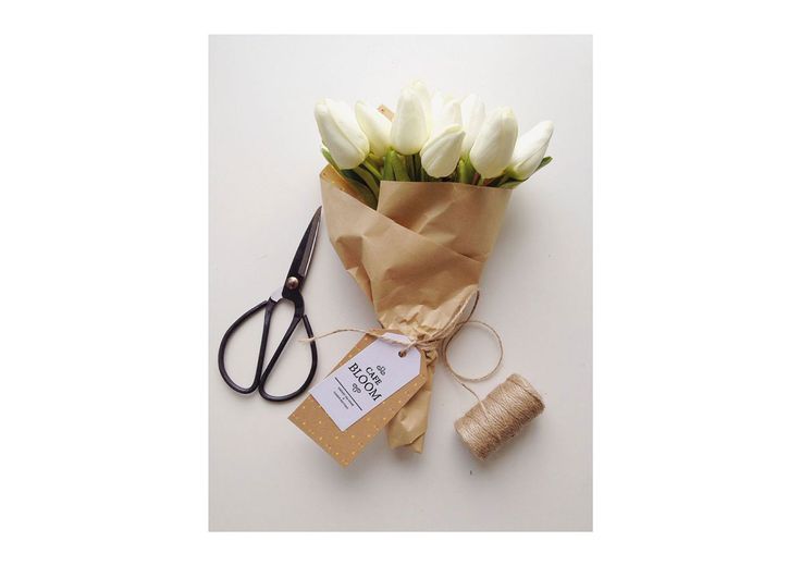 a bouquet of white tulips sitting next to a pair of scissors