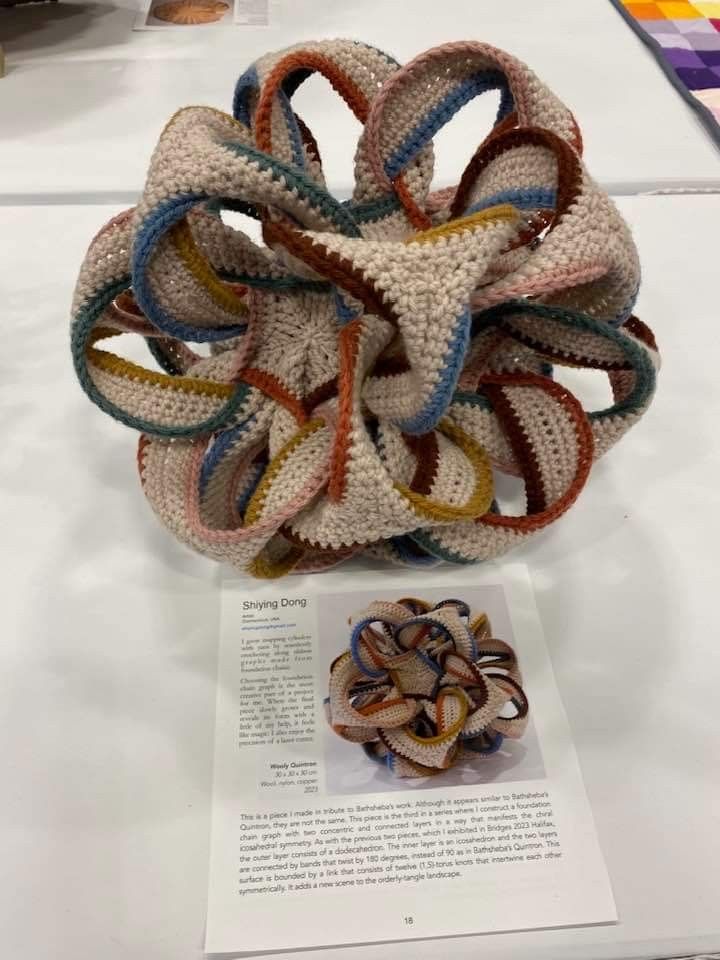 there is a crocheted object on display at the table with it's brochure