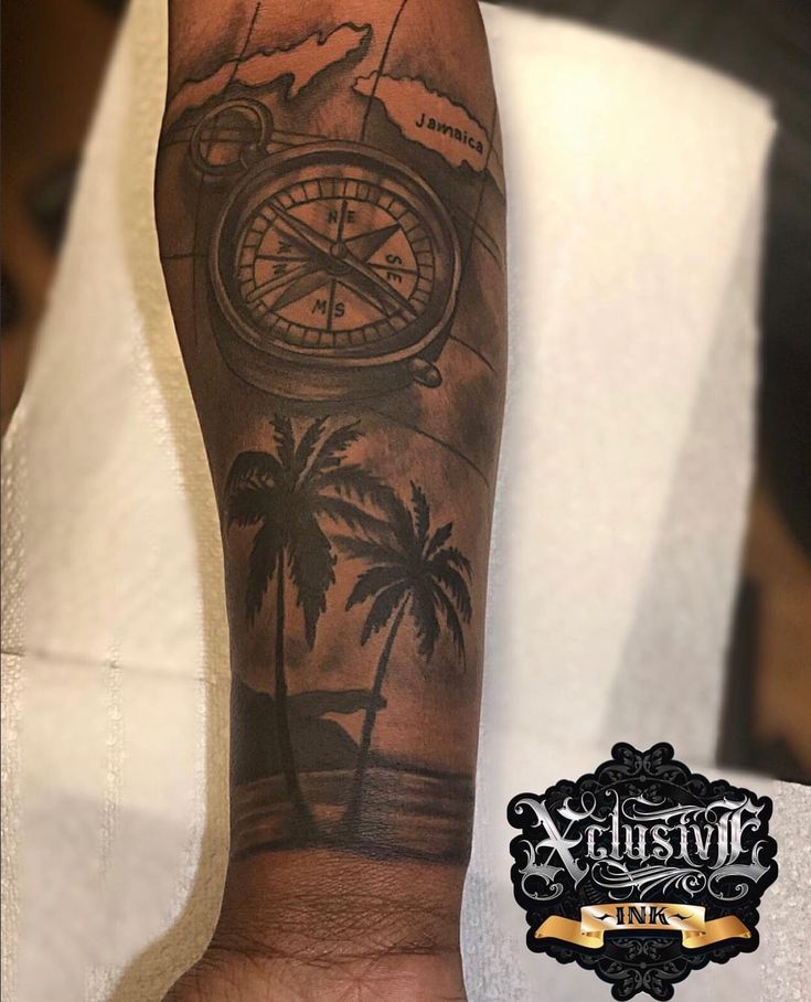 a man's arm with a compass and palm trees on it