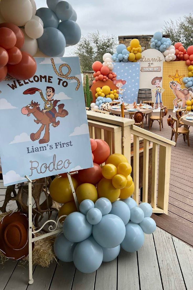 a welcome sign and balloons on a wooden deck