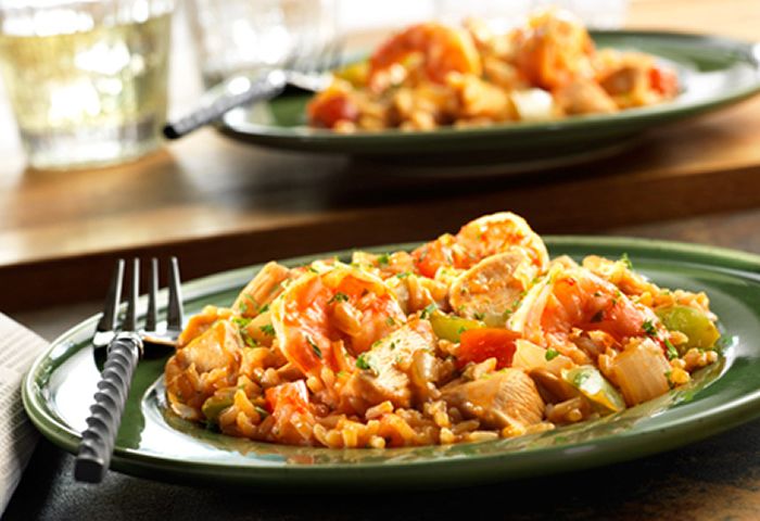 two plates with food on them sitting on a table next to a glass of water