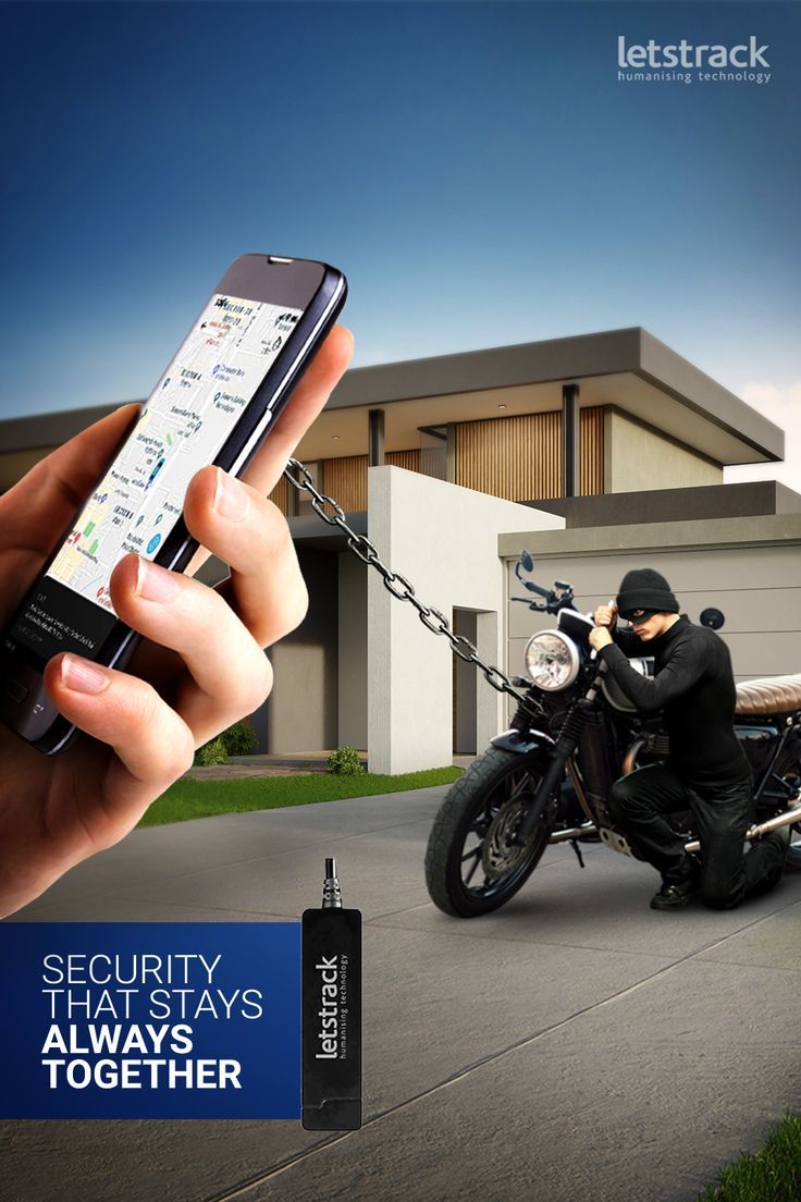 a person holding a cell phone in front of a motorcycle with a chain attached to it