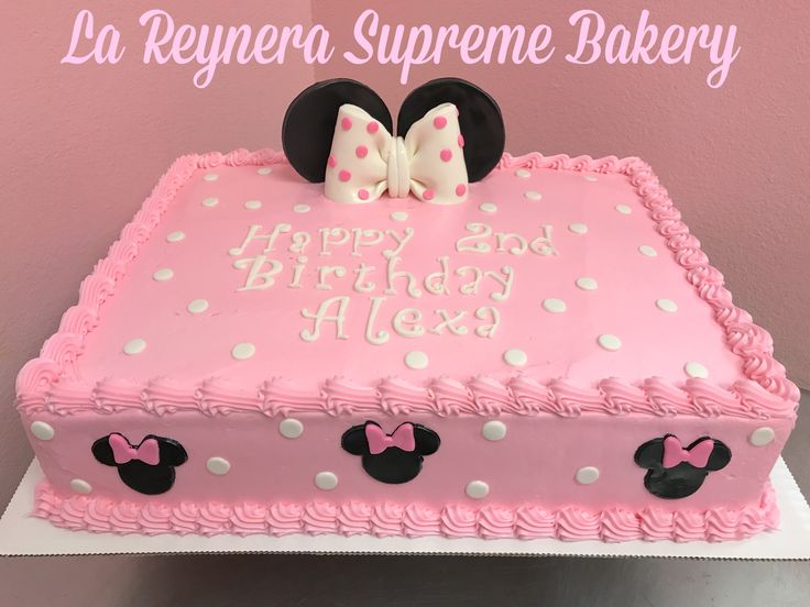 a pink birthday cake decorated with minnie mouse ears