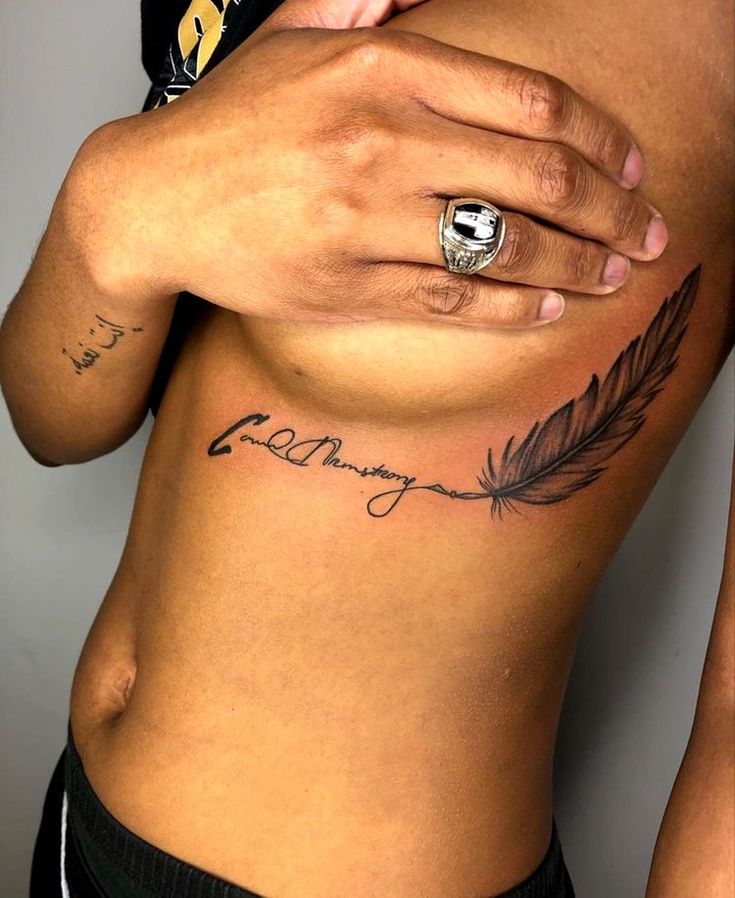 a person with a ring on their left hand and tattoos on the other side of her stomach