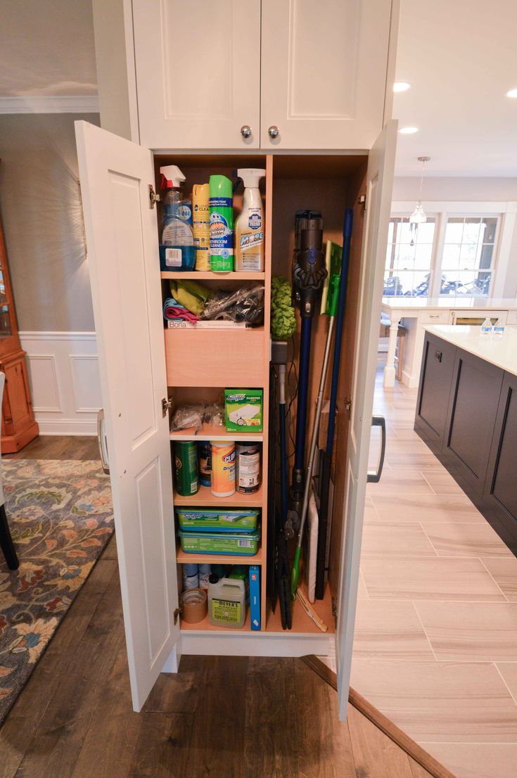 an open cabinet with items in it on the floor