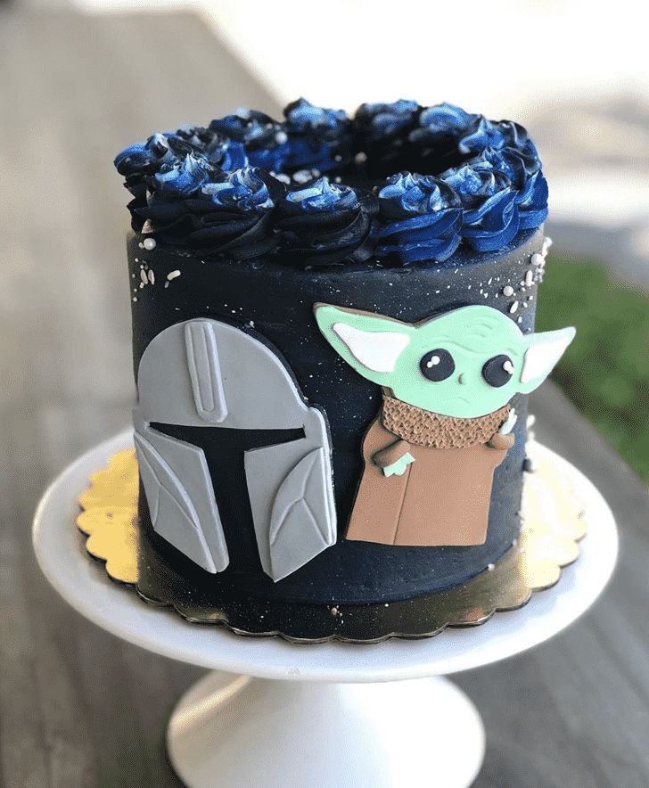 a star wars themed cake with blue frosting and fondant decorations on a plate