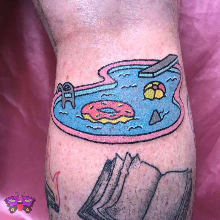 a man with a tattoo on his leg that has a pool and book in it