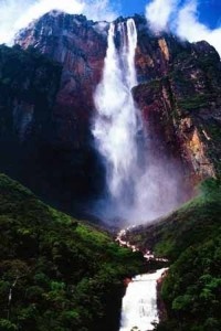 a large waterfall in the middle of a lush green forest