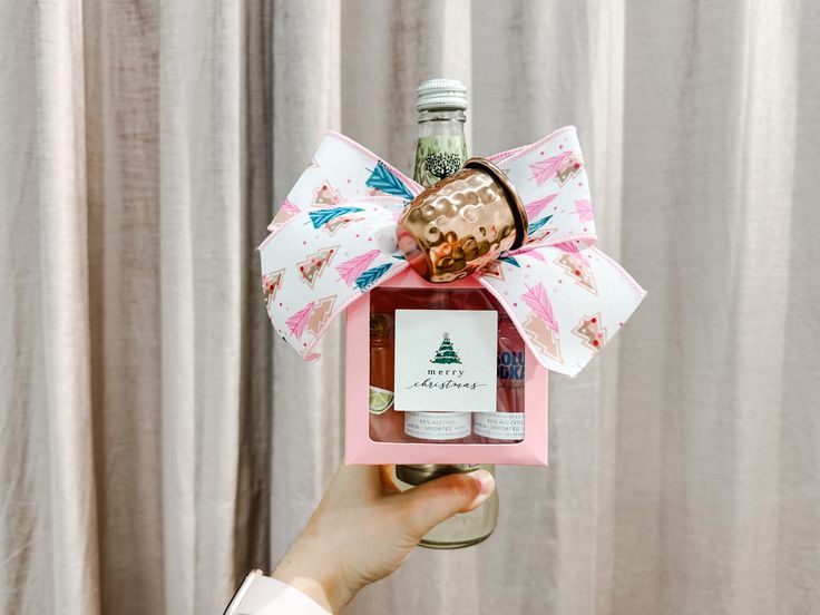 a person holding up a wine bottle in a gift box