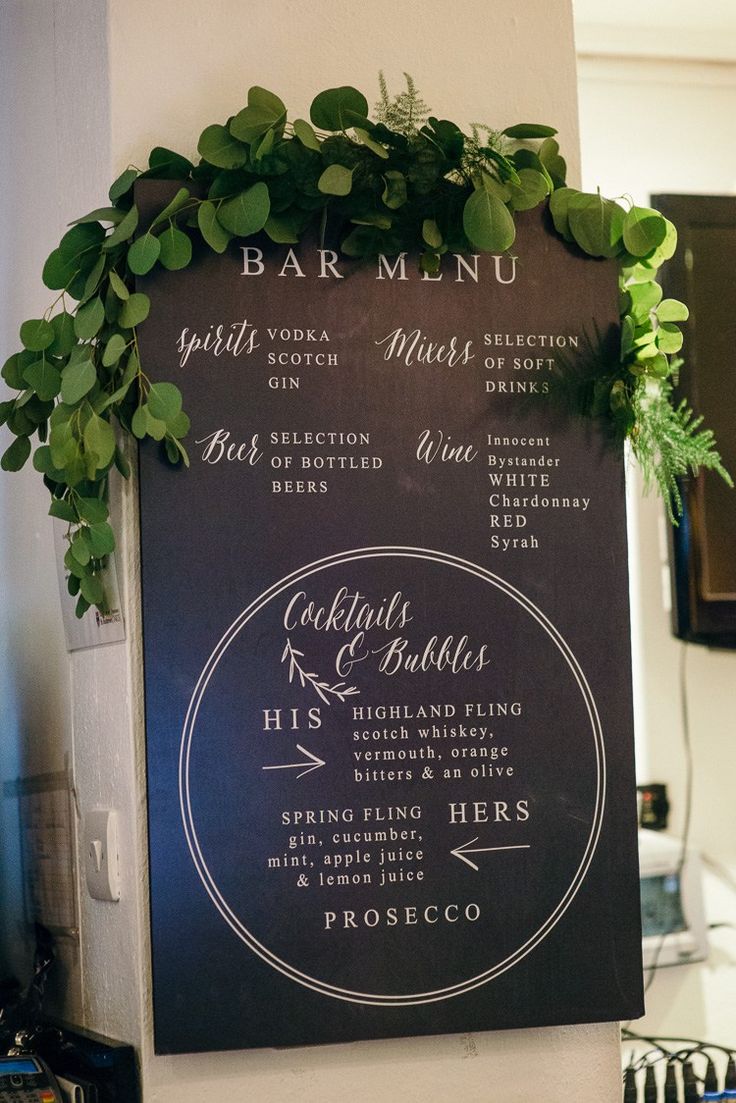 a menu hanging on the wall with greenery