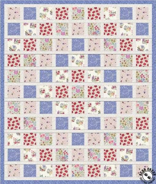 a blue and white quilt with red flowers on the border, in front of a light blue background