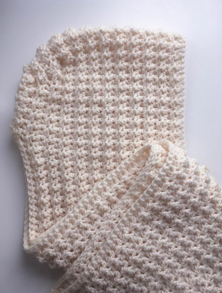 two crocheted white mittens sitting next to each other