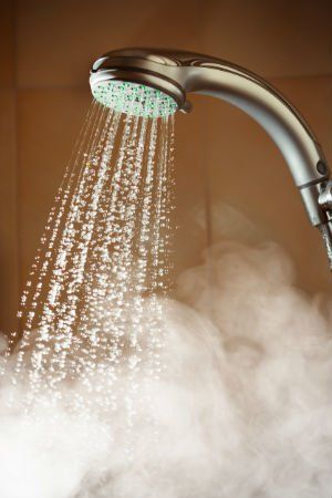 a shower head with water coming out of it's side and steam rising up