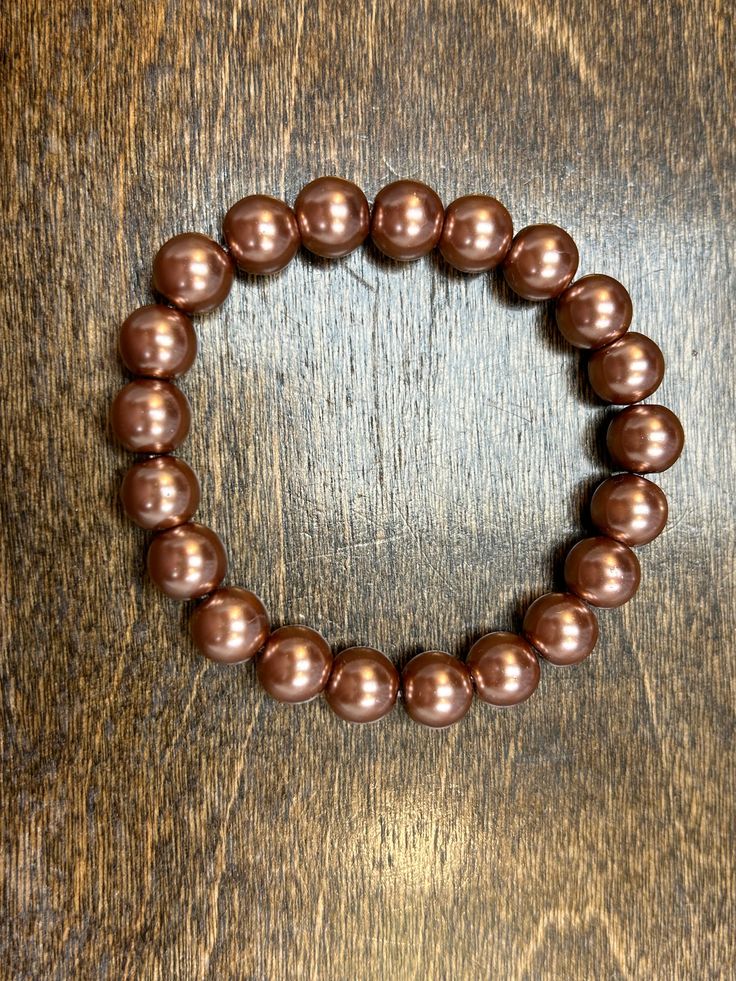 Look your best with this stylish Coffee Pearl 10mm Bracelet! Featuring a rich, deep shade, it's the perfect accessory to complete any look and bring a luxurious touch of color. Dazzle and shine, all without breaking the bank! HOC Autumn Shades, Coffee, Color