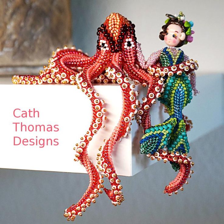 there are two figurines on top of a sign that says cath thomas designs