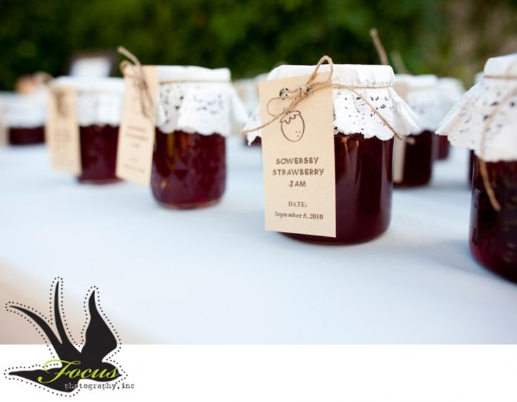 several jars of jam sitting on top of a table next to each other with tags hanging from them