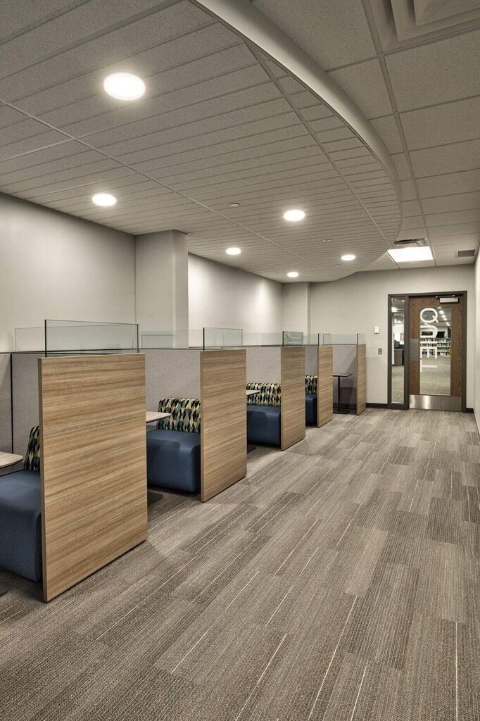 an empty office with wooden partitions and blue couches