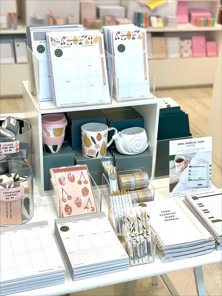 there are many items on the table in this store, including cups and mugs