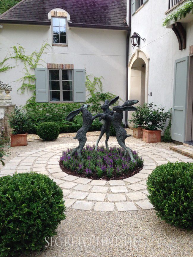 a garden with some plants in front of a house