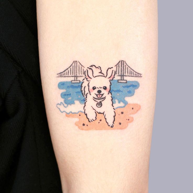 a small white dog on the arm with a bridge in the back ground behind it