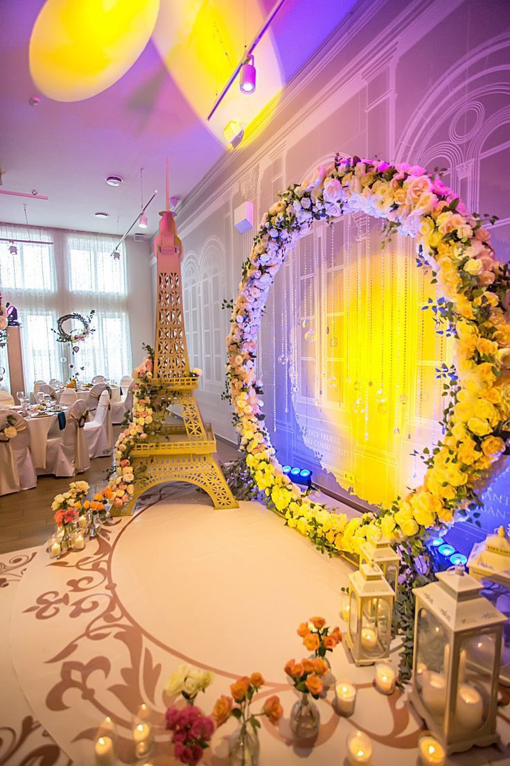 the eiffel tower is surrounded by flowers and candles in front of a backdrop