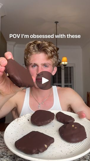 a woman holding up chocolate covered cookies on top of a white plate with the words pov i'm obsesed with these