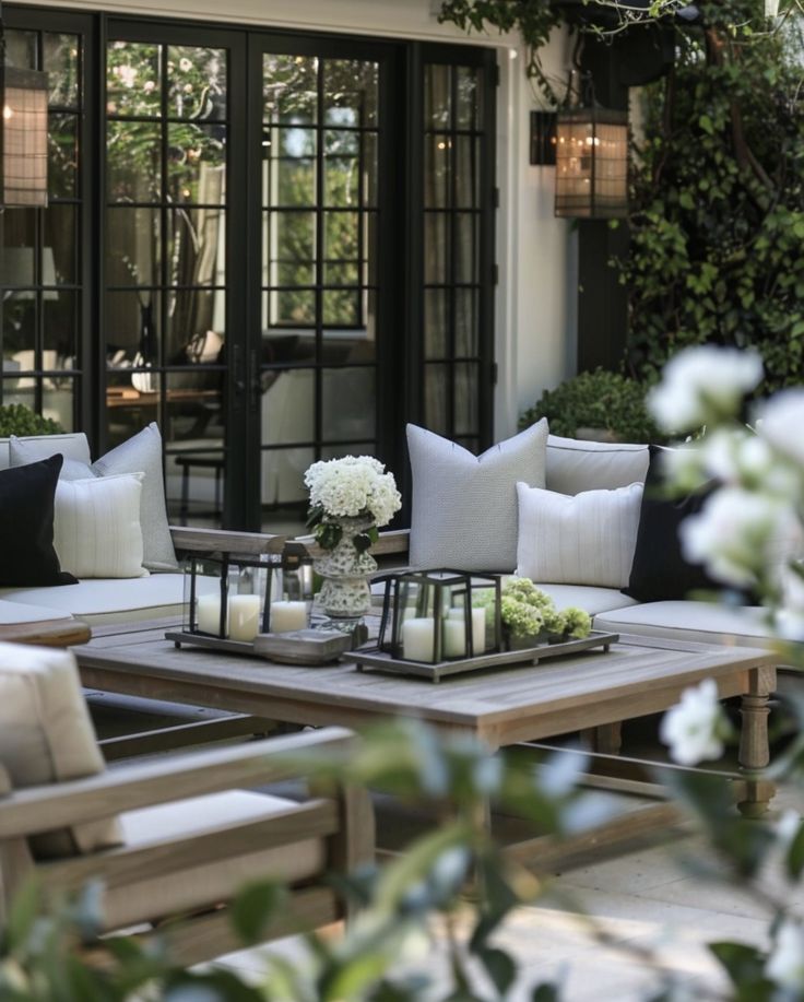 a table with candles and flowers on it in front of a glass door that leads to a patio