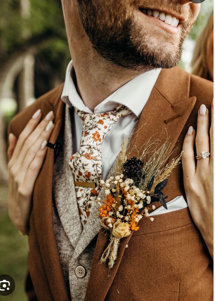 a man in a suit and tie with flowers on his lapel