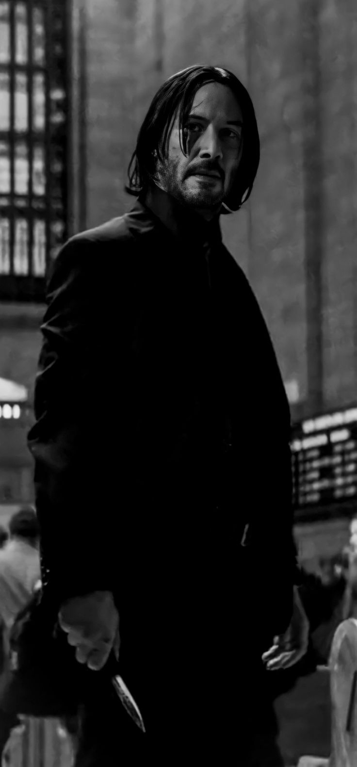 a man with long hair standing in front of a building holding a knife and looking at the camera