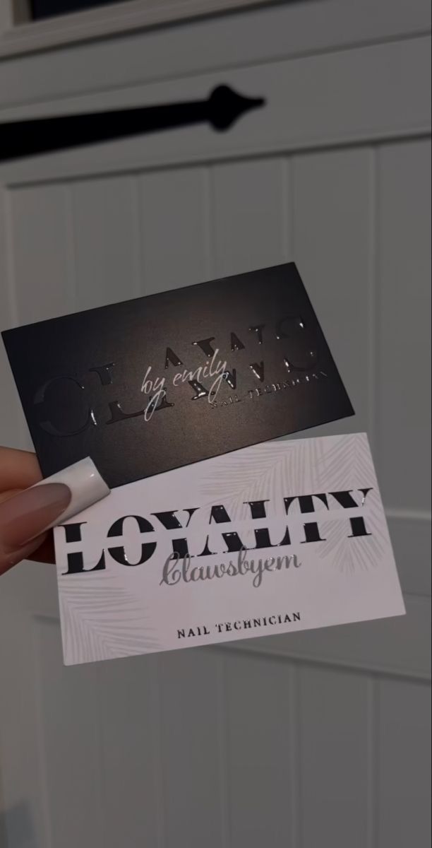 a person holding two business cards in their hand