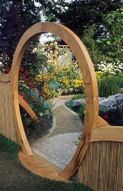 a wooden arch in the middle of a garden