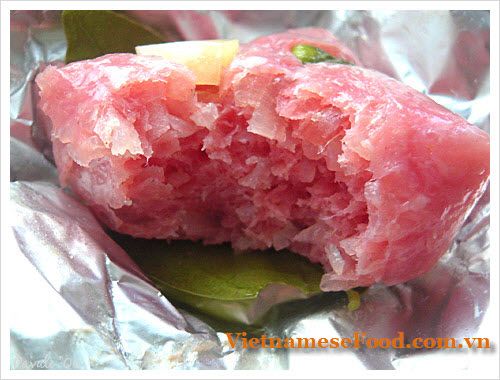 a piece of meat sitting on top of aluminum foil with a green leaf around it