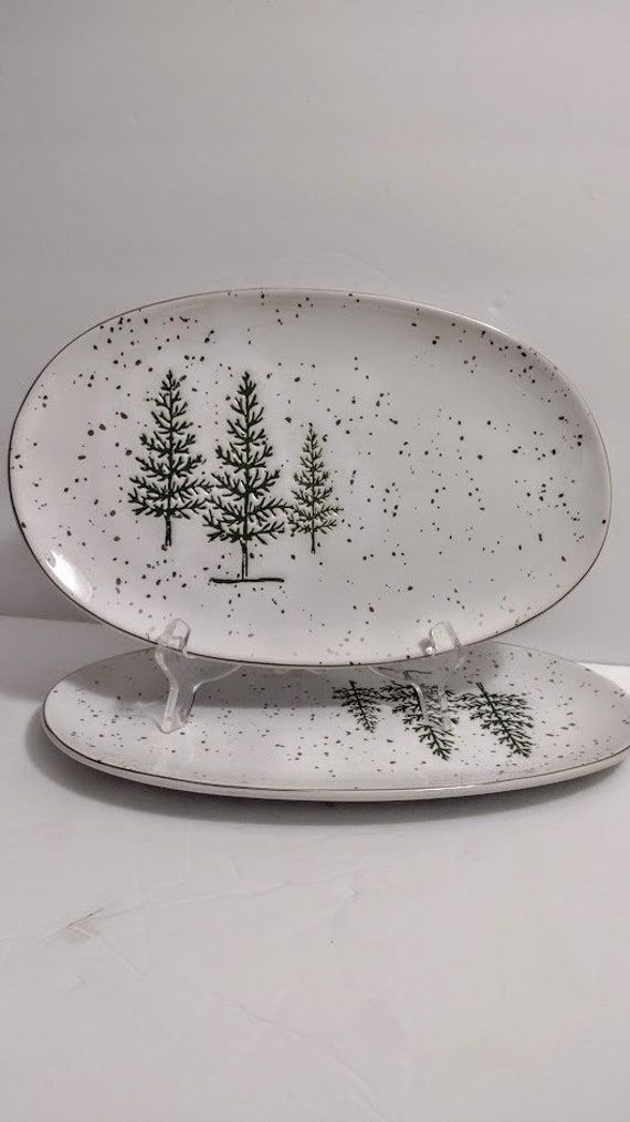 two plates with trees on them sitting next to each other