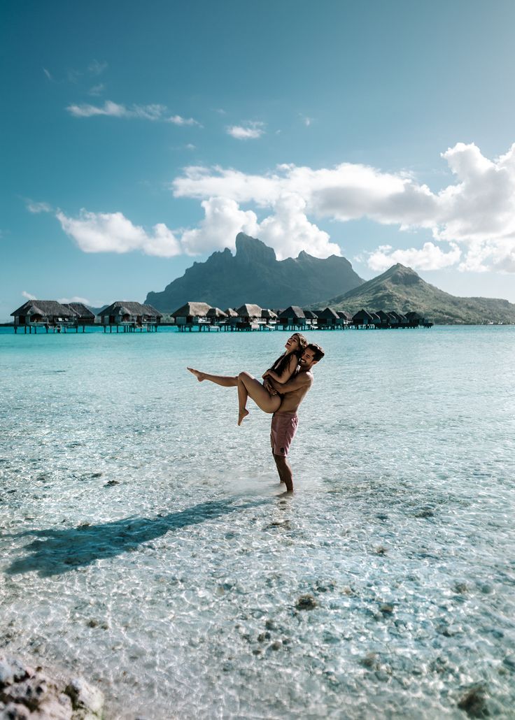 a man is holding a woman in the water