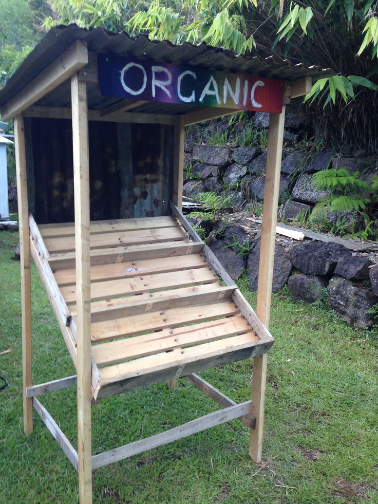 a wooden bed frame sitting in the grass