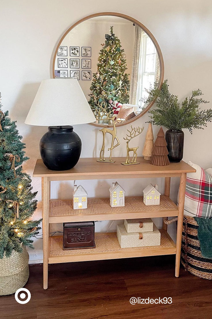 a living room with a christmas tree and decorations on the shelf next to a mirror