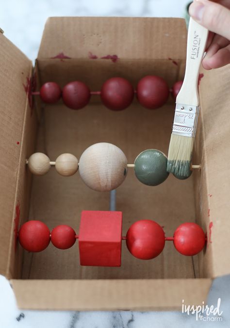 someone is painting the inside of a cardboard box with balls and paintbrushes in it