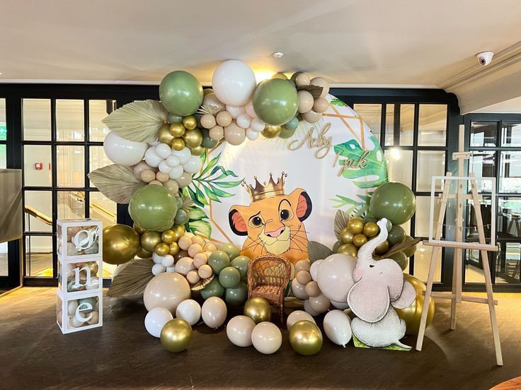 the balloon arch is decorated with balloons, animals and other decorations for a baby's first birthday